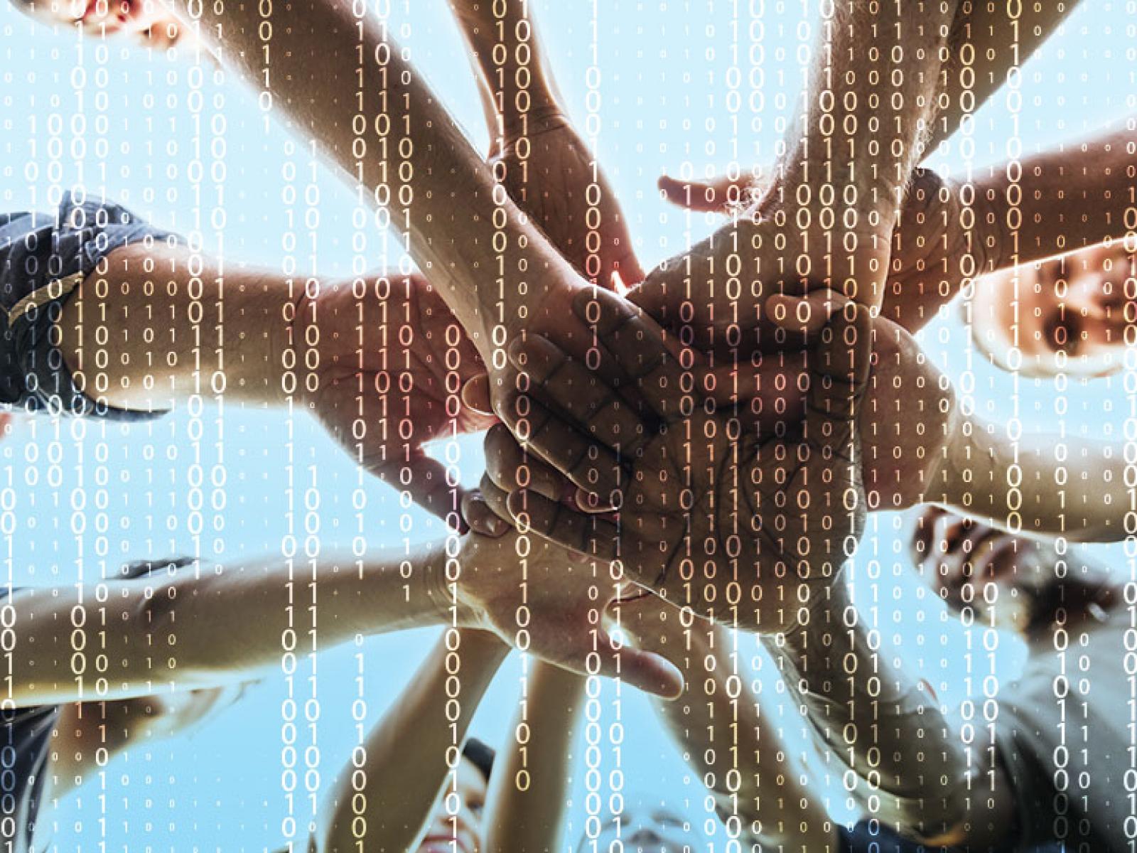 Diverse group of people, hands together with computer code in background