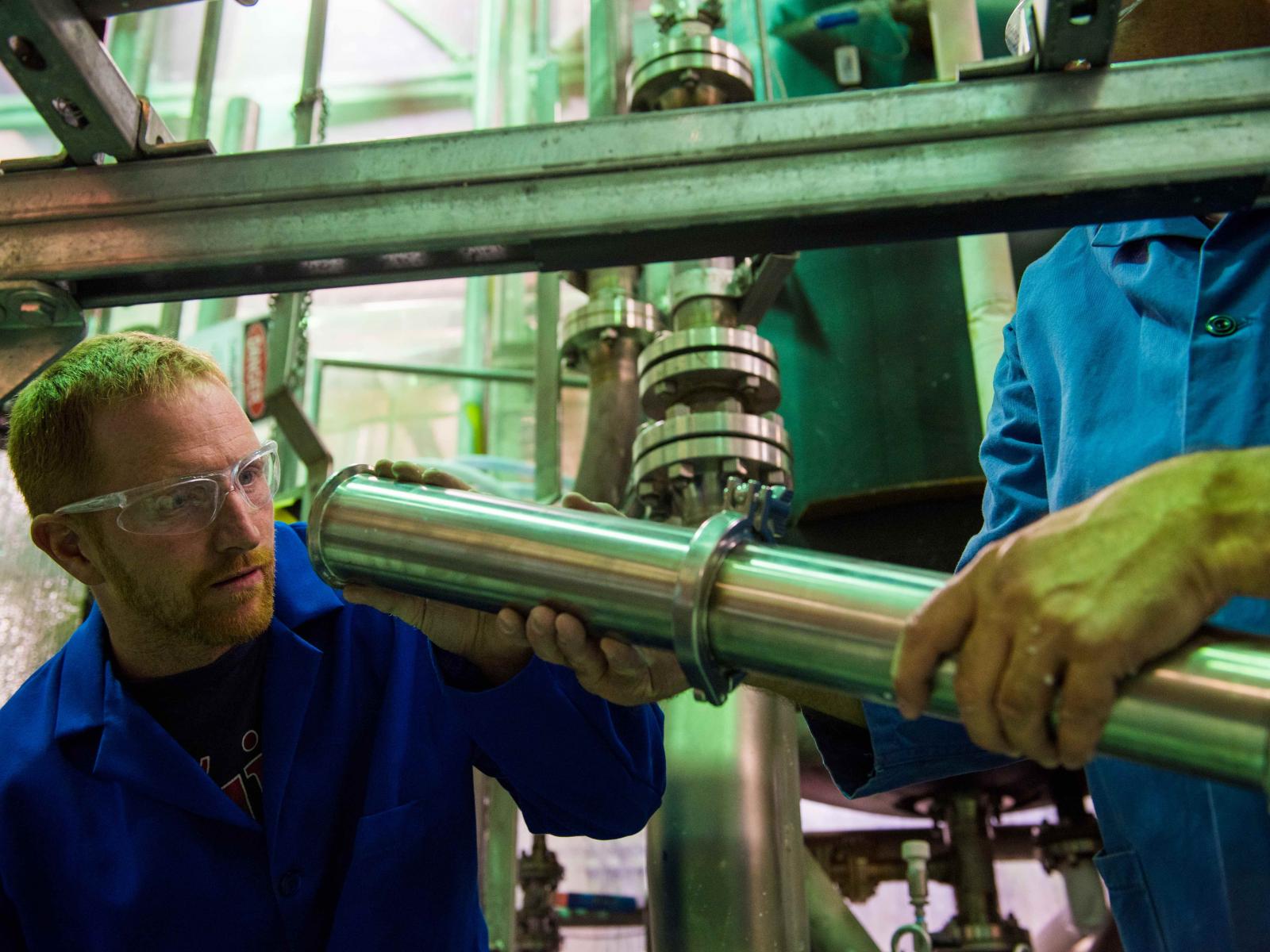 Mechanical engineer Nathan Phillips inspects a 3-inch steel pipe that contains a special filter invented at PNNL
