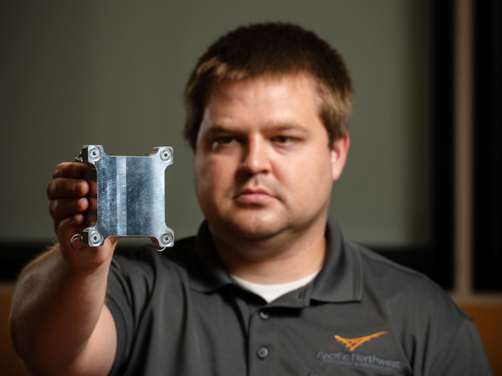 Bruce Pierson holds the metal cube launched into space aboard the Polaris Dawn mission.