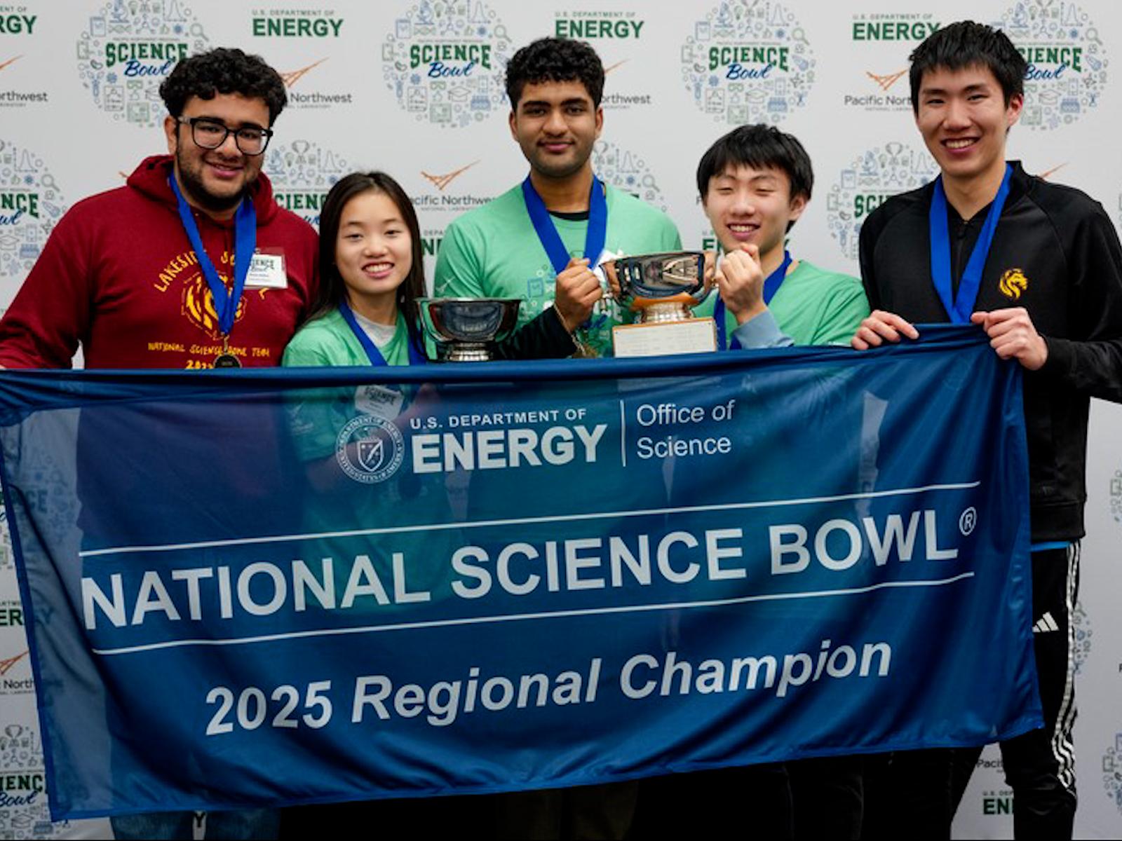 Five people standing together, holding trophies and a banner that reads, "U.S. Department of Energy | Office of Science. National Science Bowl® 2025 Regional Champion."