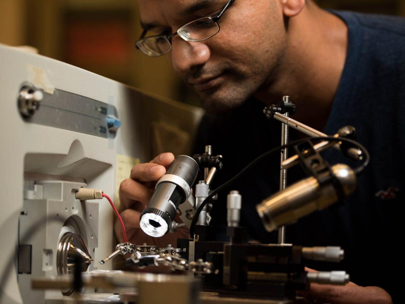 photo of man with glasses looking at a scientific instrument