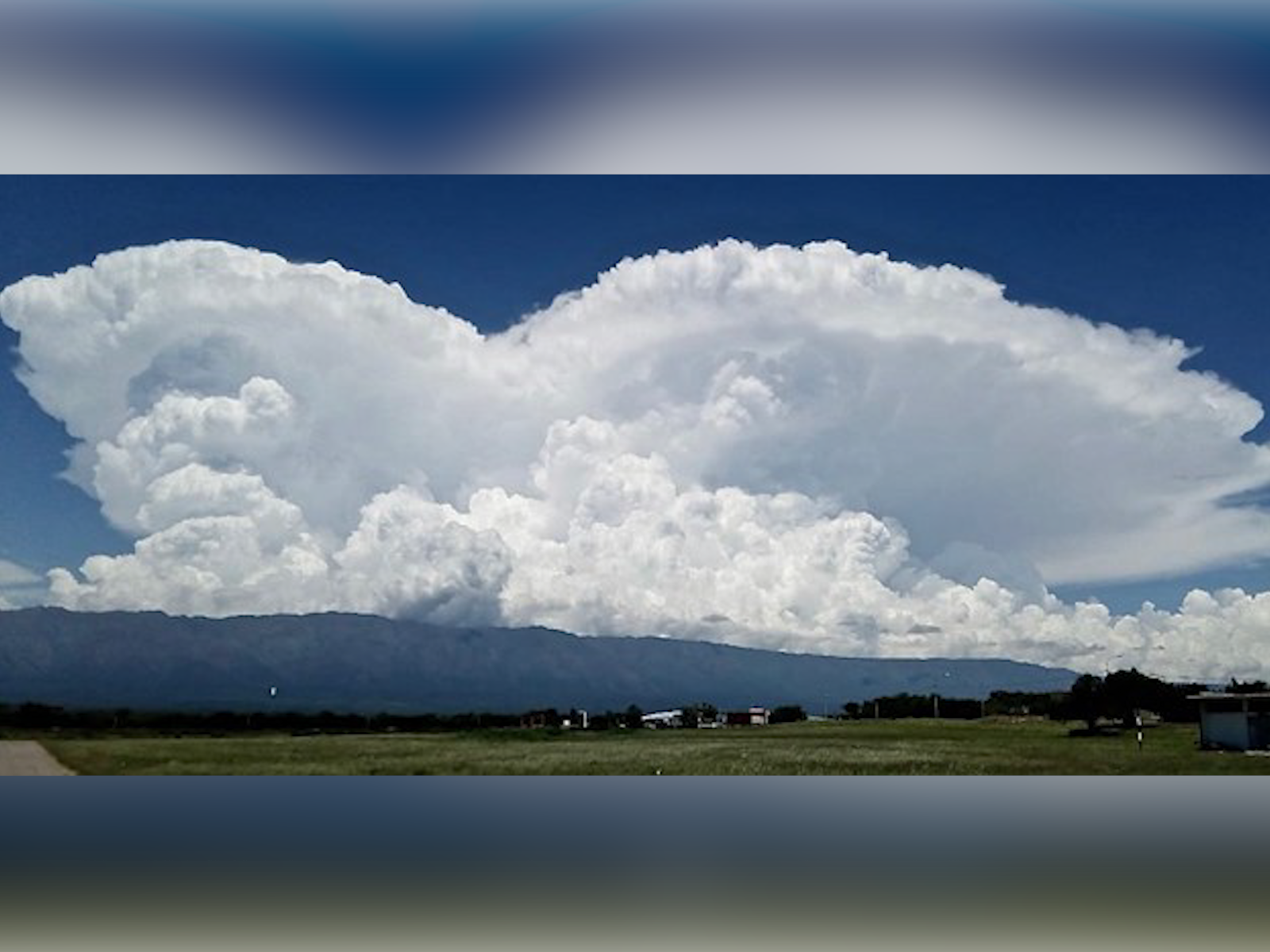 Photograph of large clouds over mountains