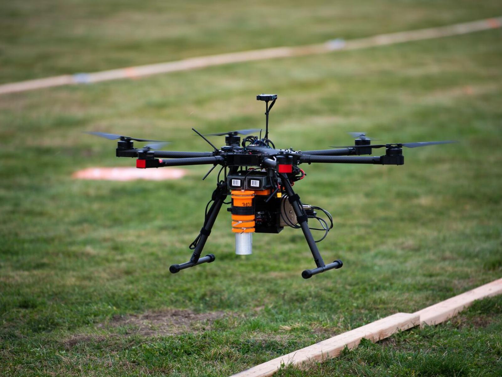 Drone flying over a grass field and wood for analysis testing