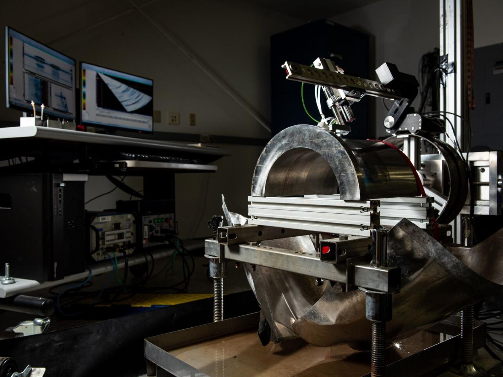 Nondestructive examination equipment in a lab with a computer in the background