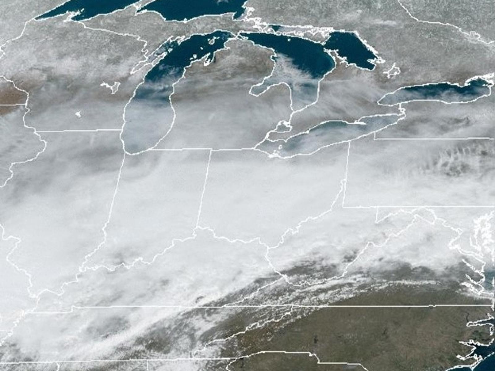Satellite image of the Great Lakes region covered with clouds.