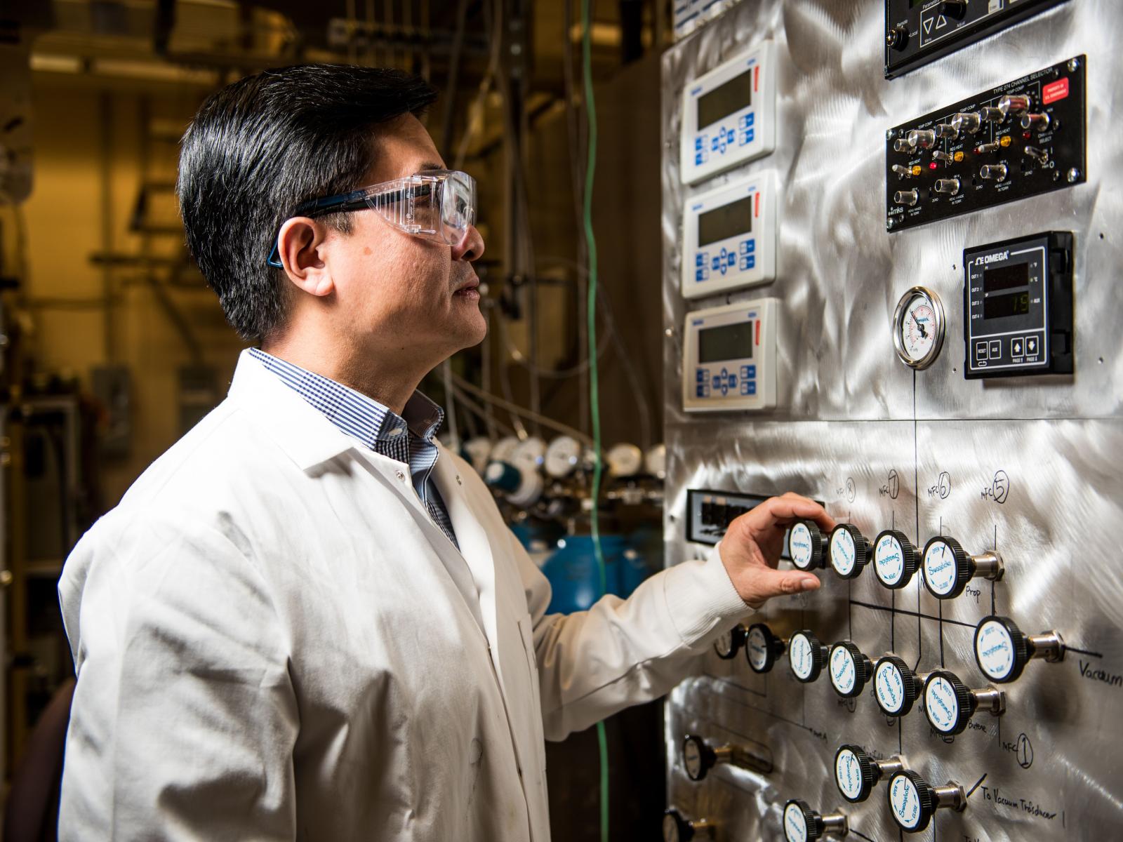 Yong Wang, in lab safety gear, operating machinery
