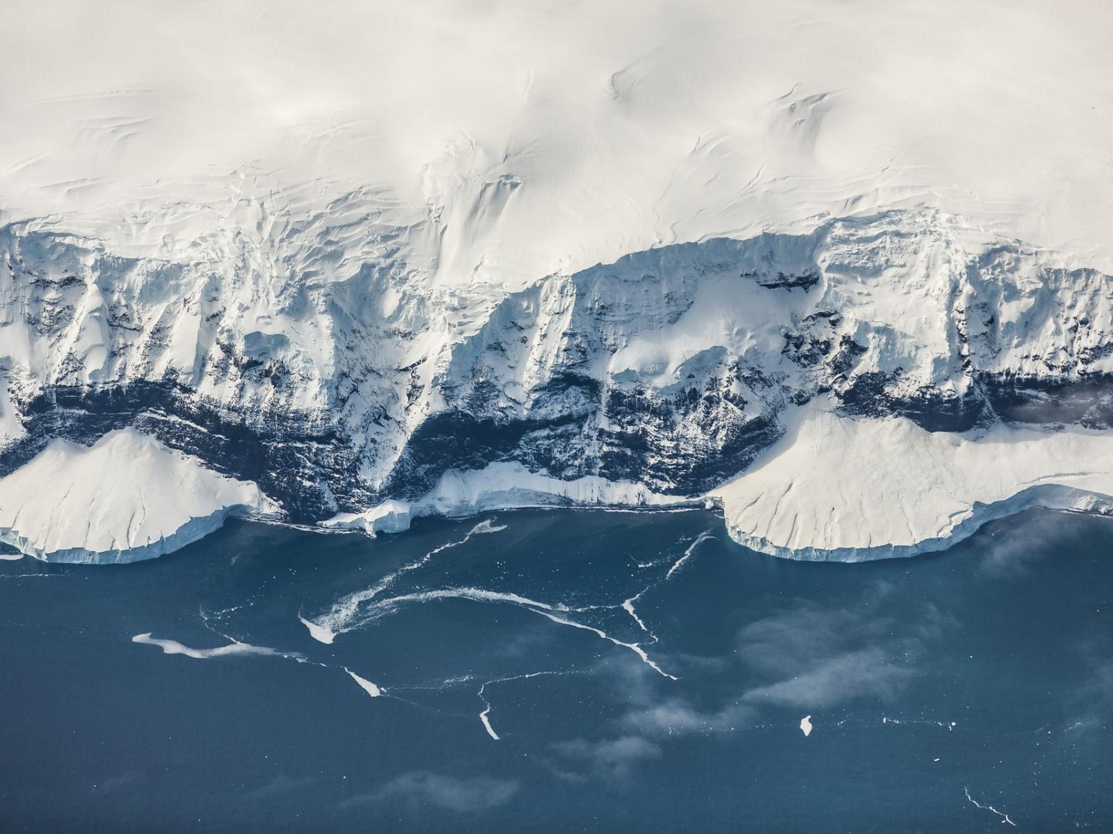 white ice sheet bordering a blue sea