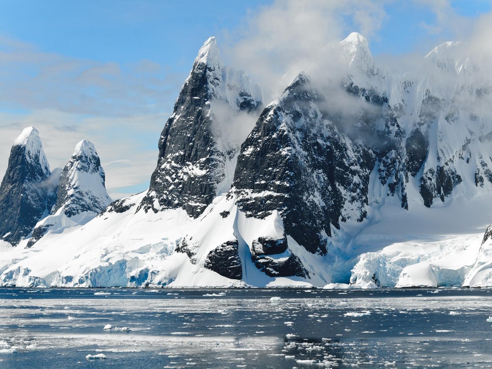 Photograph of snowy cliffs at the edge of an icy ocean