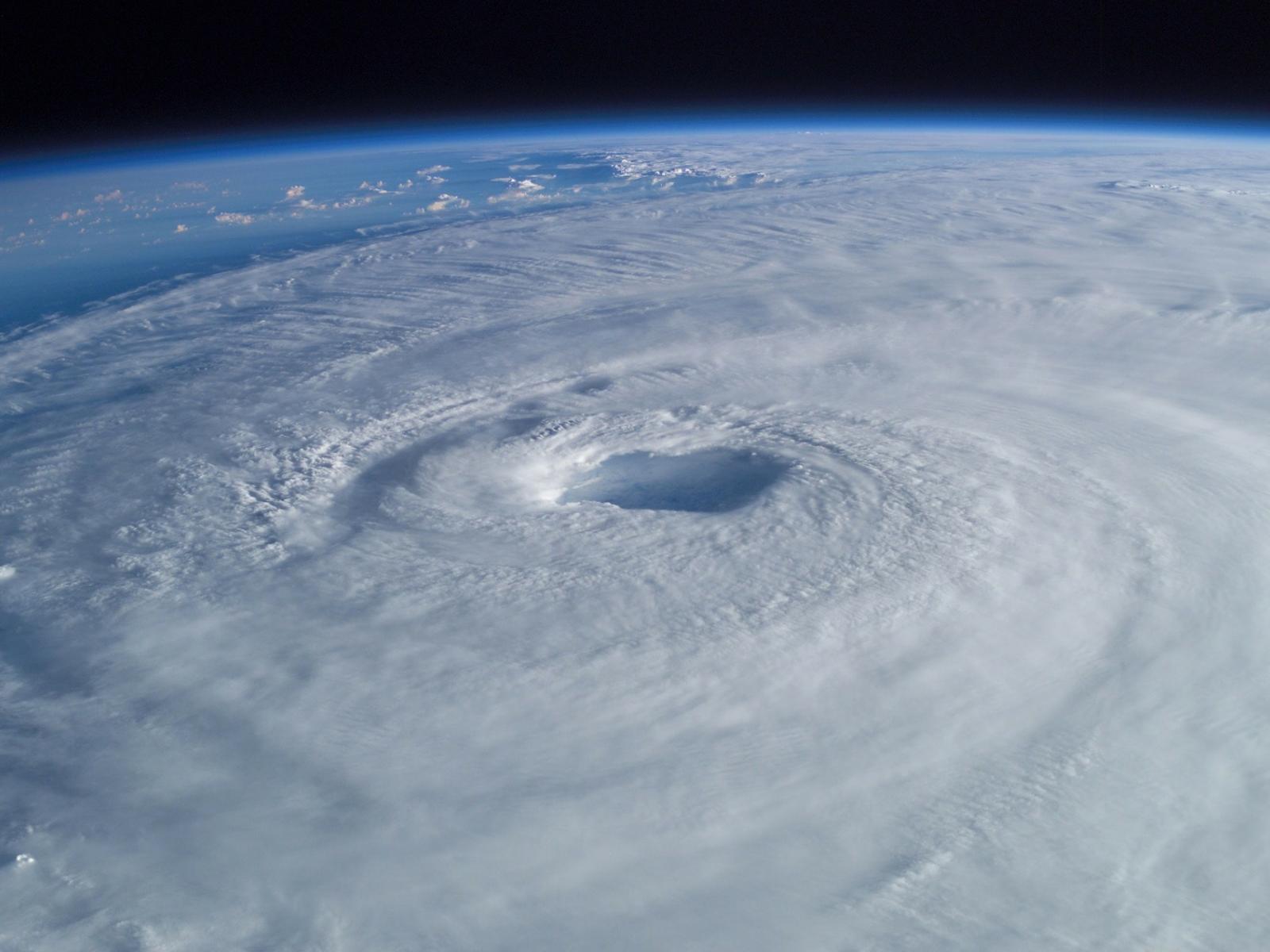This image depicts a hurricane from above, clouds encircling as the storm forms.