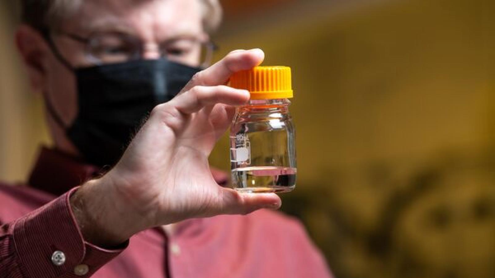 Robert Dagle holds a vial of fuel created from biomass conversion.