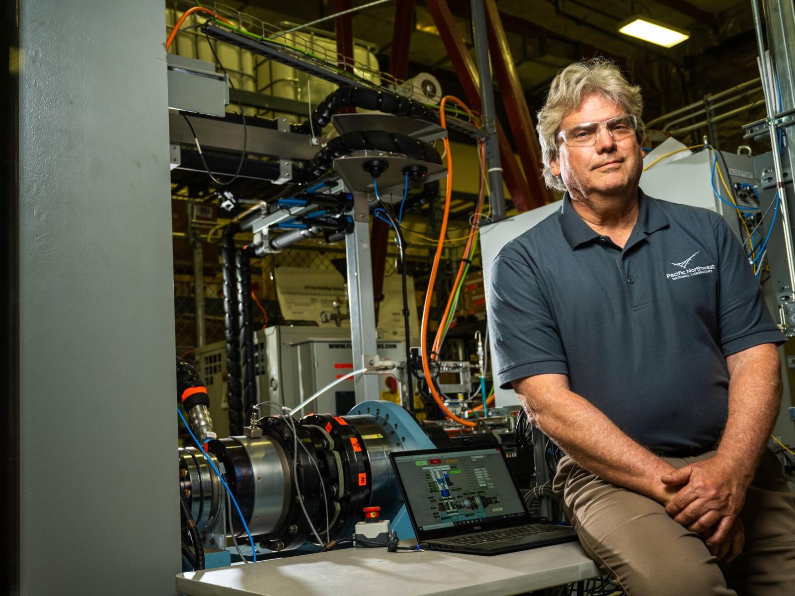 Mechanical engineer Eric Berglin is pictured in the lab with the Bushings Test Stand.