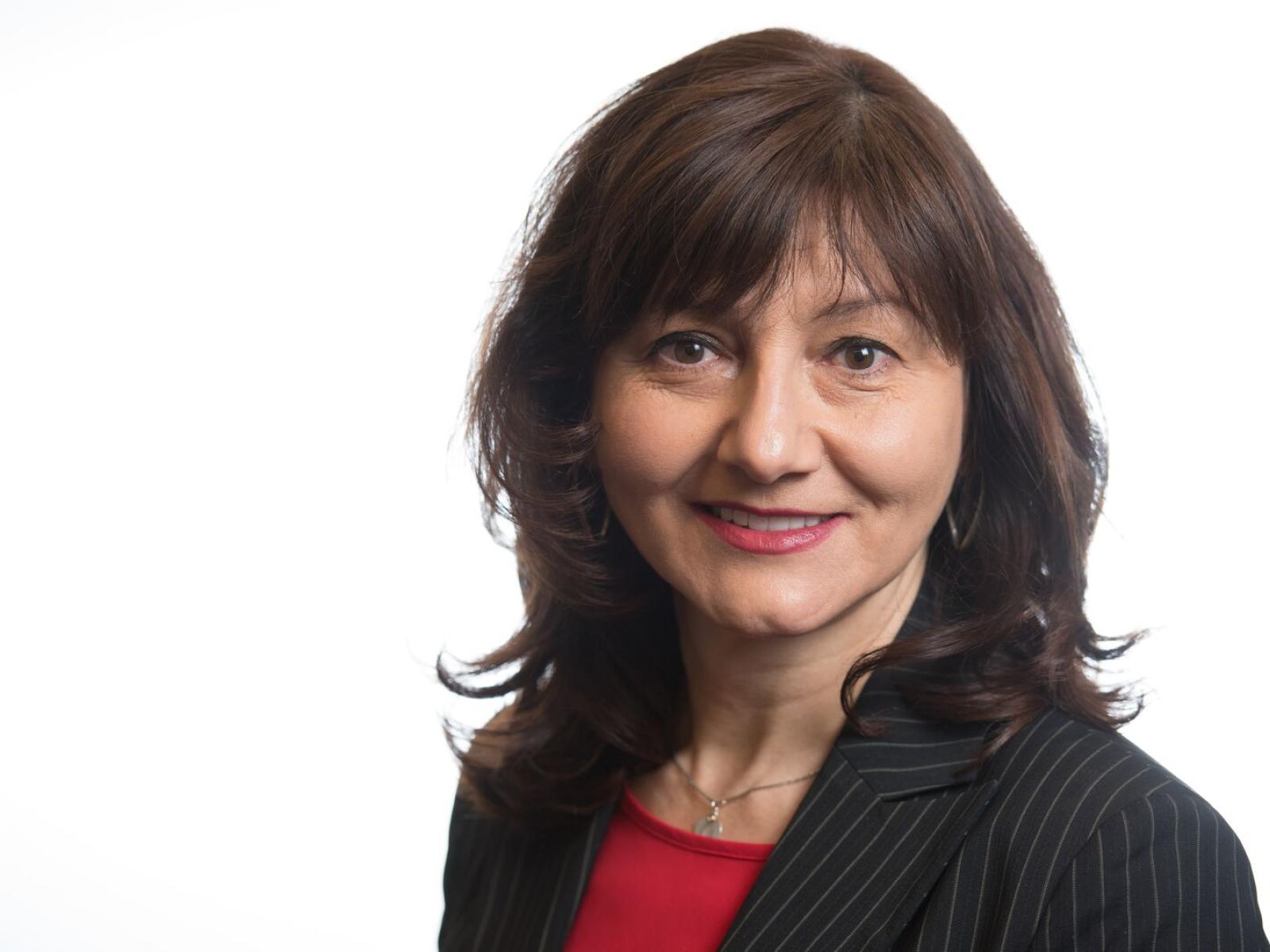 Dark-haired woman in black blazer, red shirt