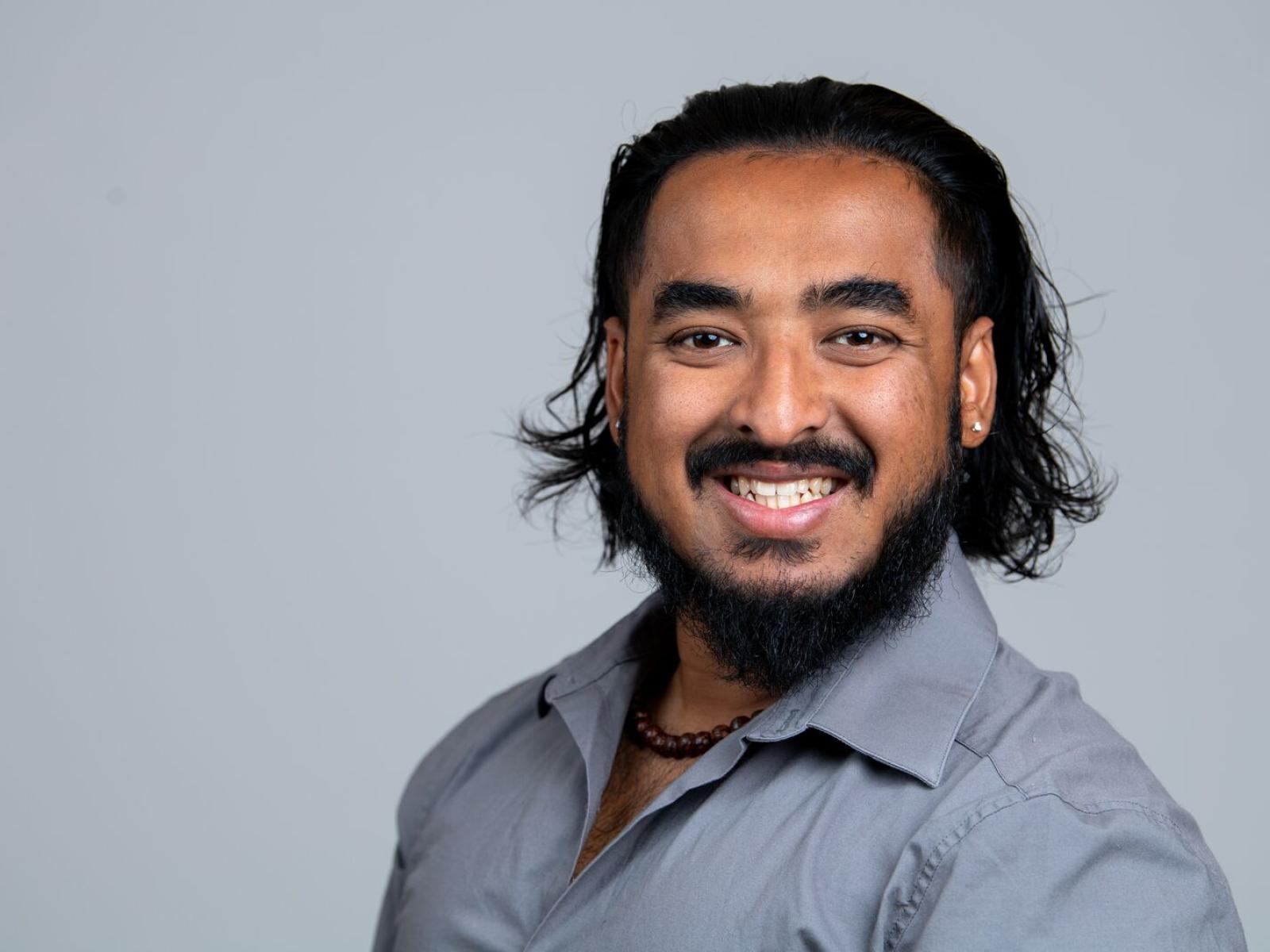 Animesh Pattanayak is pictured from the shoulders up, smiling toward the camera