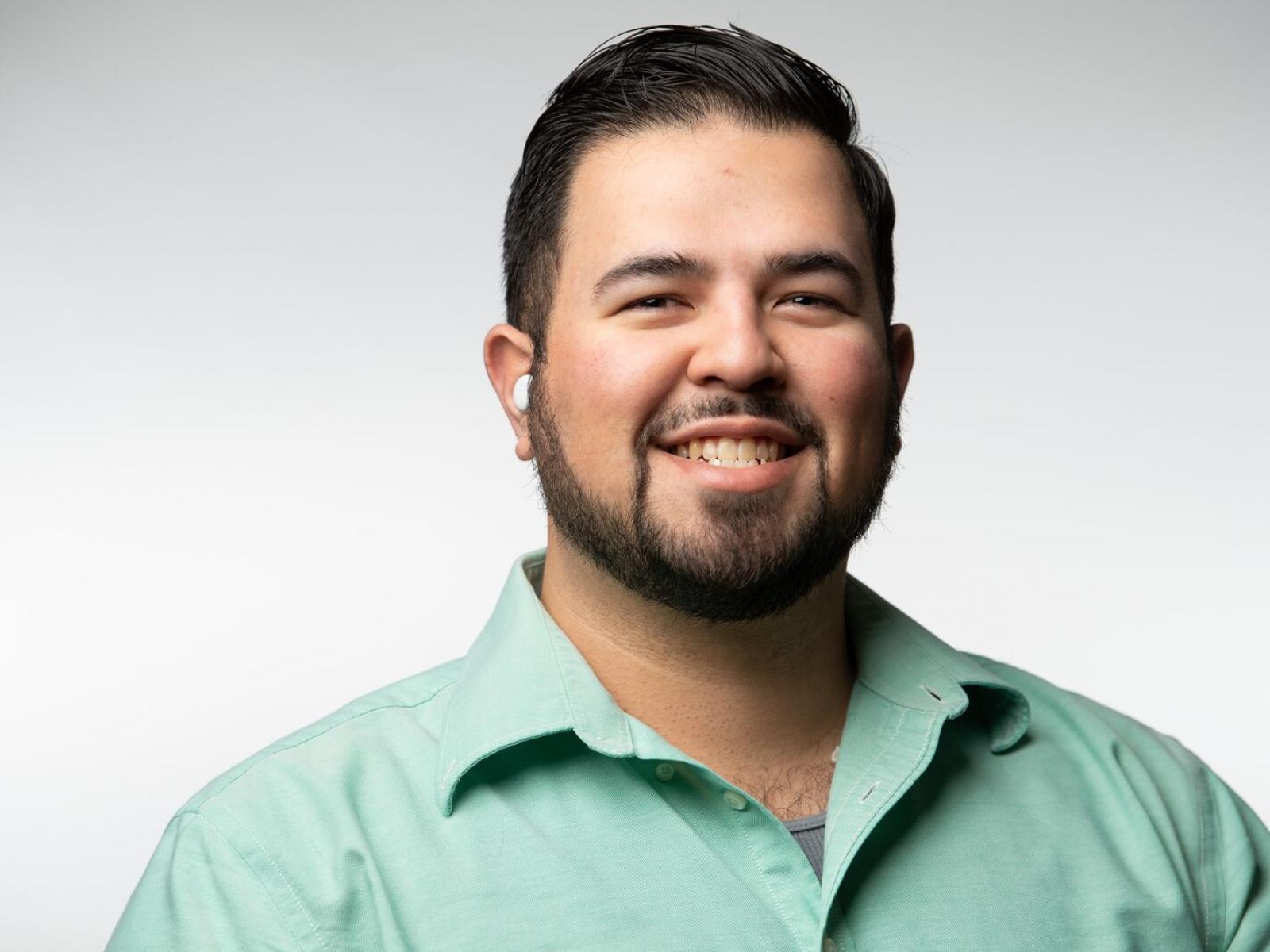 Adan Schafer Medina, with dark hair wearing a green shirt