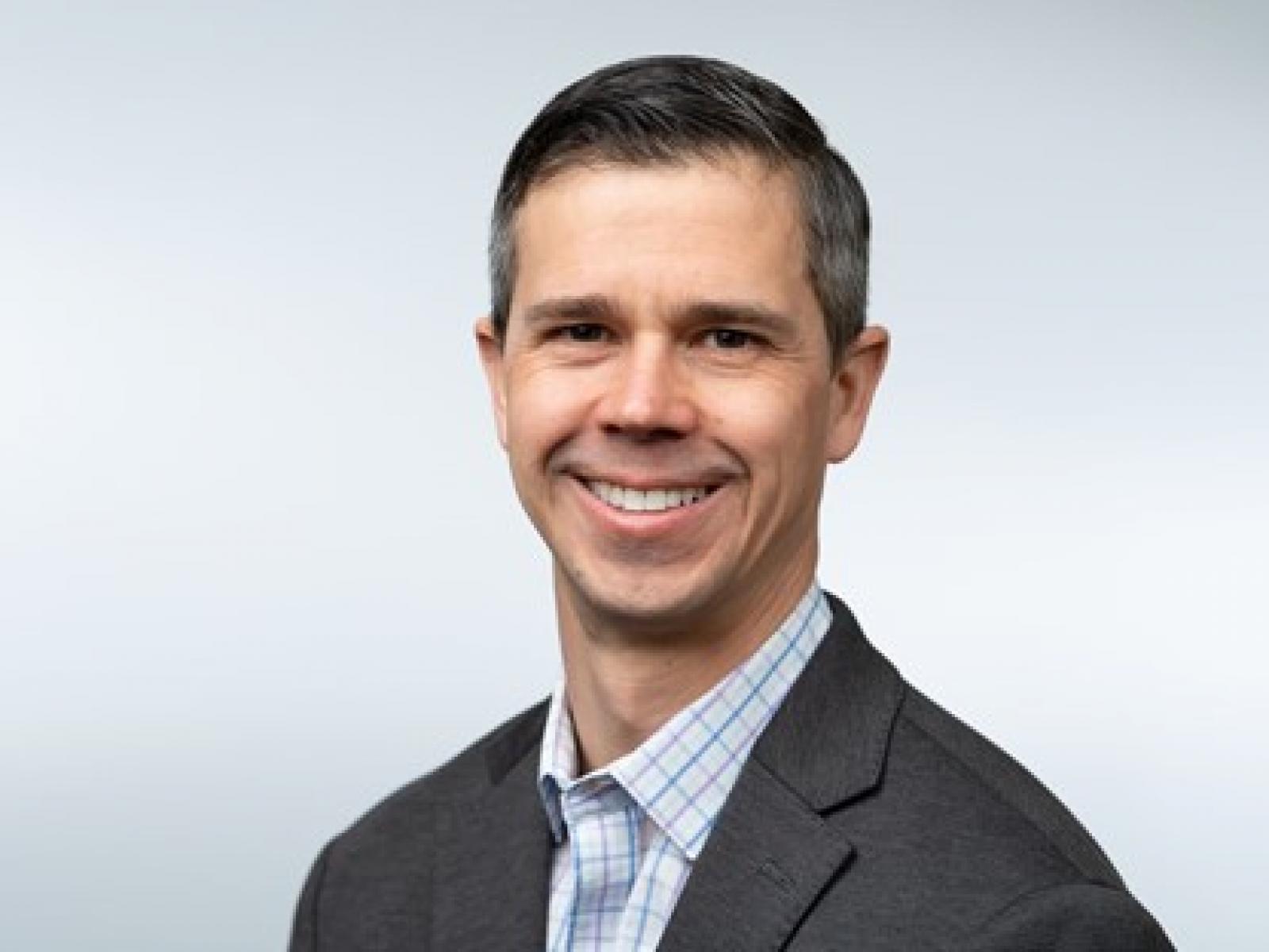 Image of a smiling man dressed in business attire
