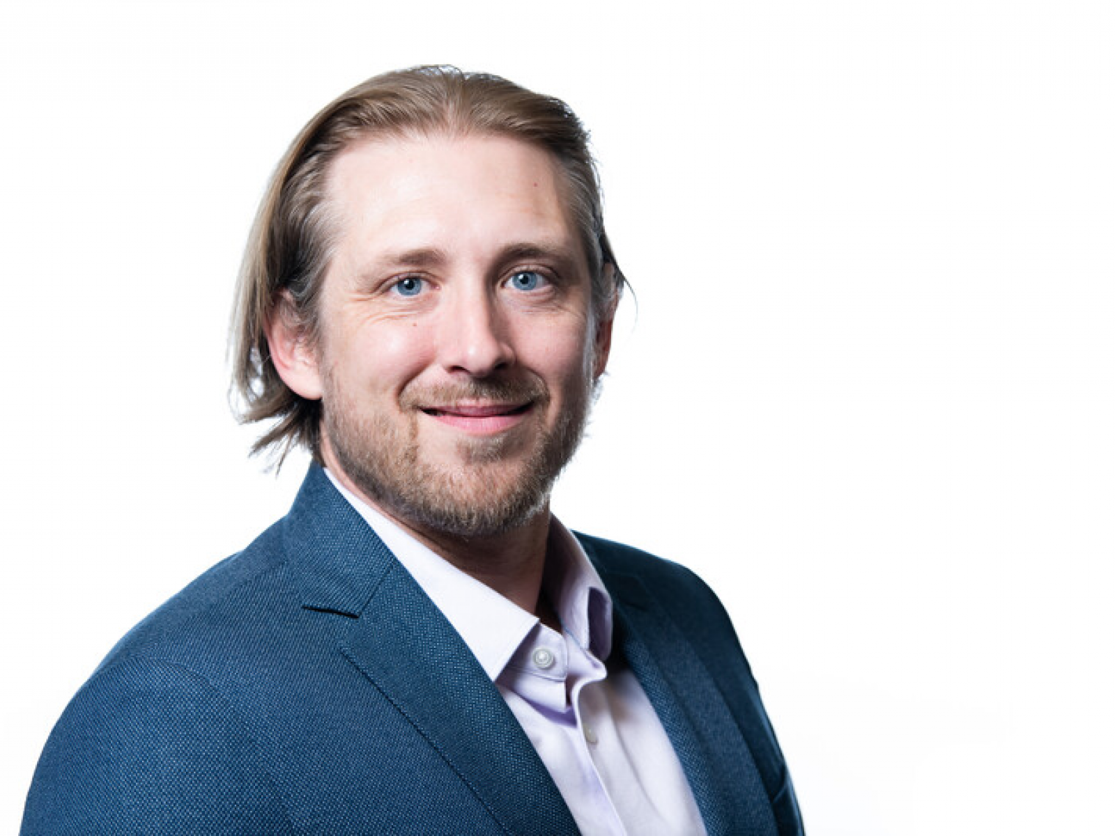Smiling man with medium length hair wearing business atire