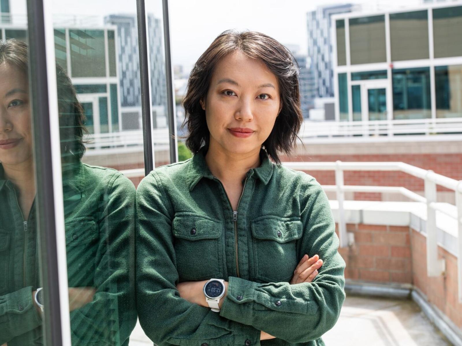 image of a scientist in a green shirt standing outside