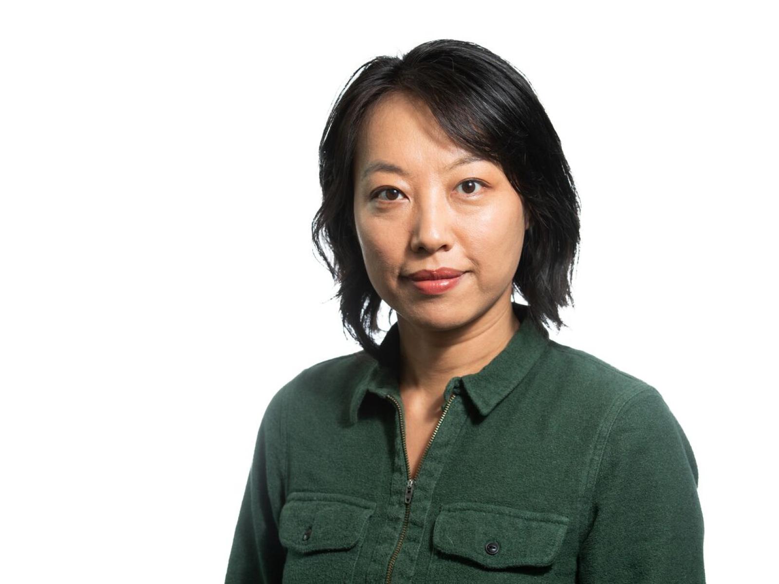 scientist in a green shirt with shoulder length black hair