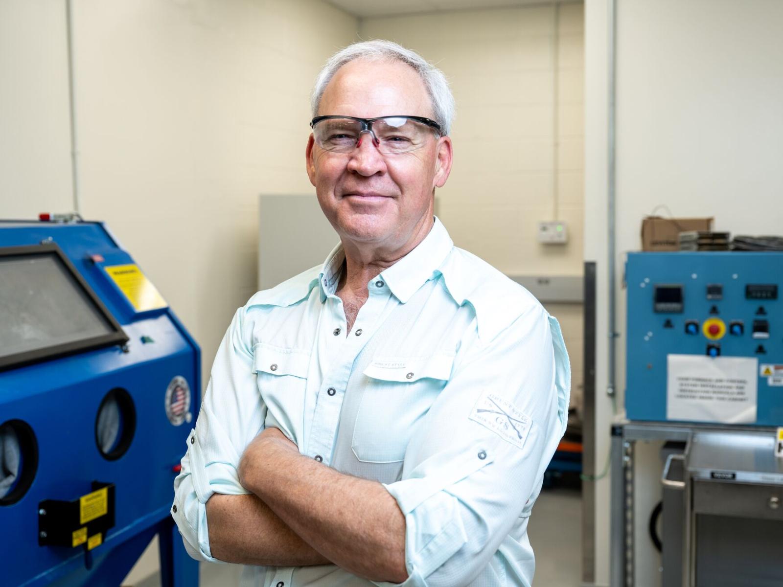 Portrait photo of Gary L. Smith, wearing safety goggles, inside a laboratory 