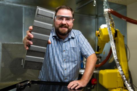 Researcher holding cold spray treated component