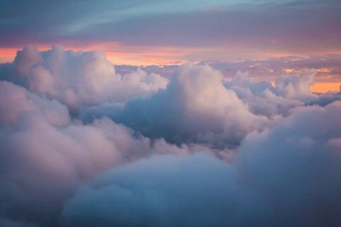 Photograph of cloud tops with a warm sunset in the background