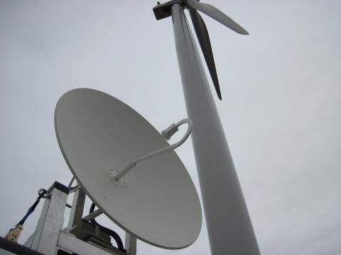 Parabolic attenna next to wind turbine