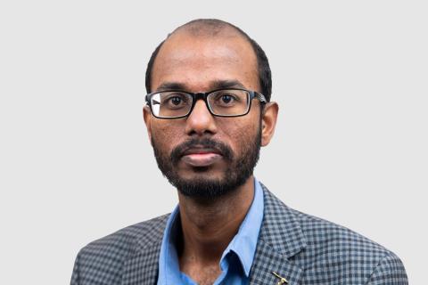 Headshot of Sai Munikoti with a light gray background