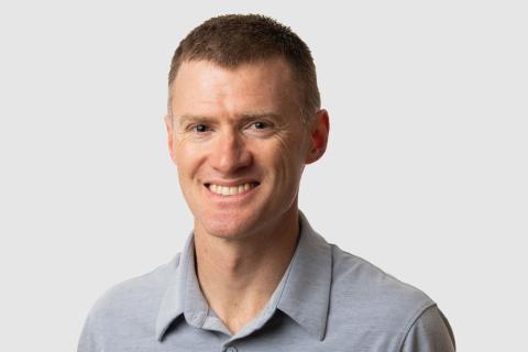 Headshot of Dan Nally with a light gray background