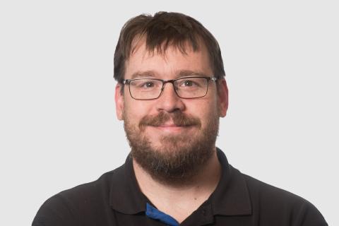 Headshot of Mike Parker with a light gray background