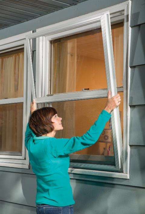 Person installing exterior storm window