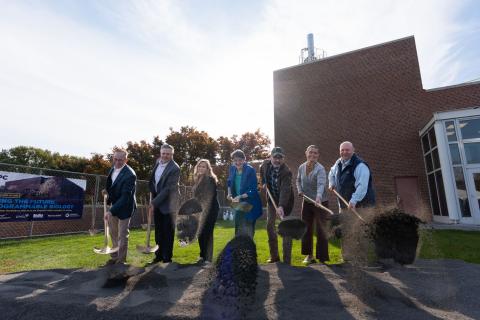 Seven people shoveling dirt