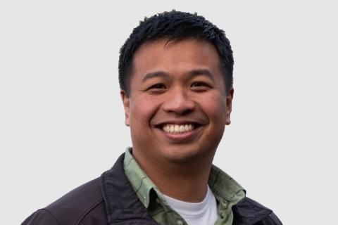 Headshot of Tim Vega with a light gray background