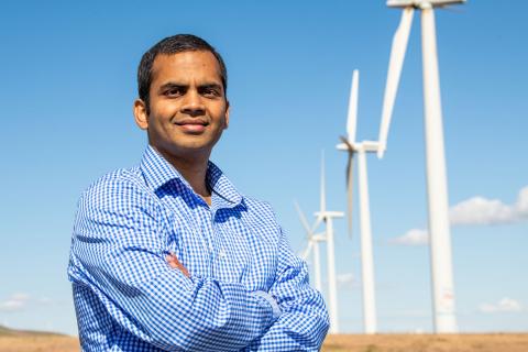 Man standing in front of wind turbines