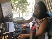 Casual photograph of a woman sitting at a computer workstation