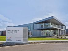 The exterior of the GSL building, with the building sign in the foreground