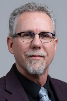 Man with gray hair wearing glasses