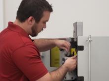 Graduate student researcher Will Smith loads a sample into an atomic force microscope.