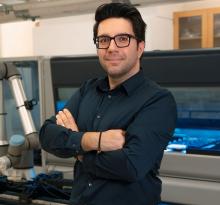 Photograph of a man standing in a lab