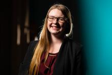 Woman with long blond hair and glasses smiling