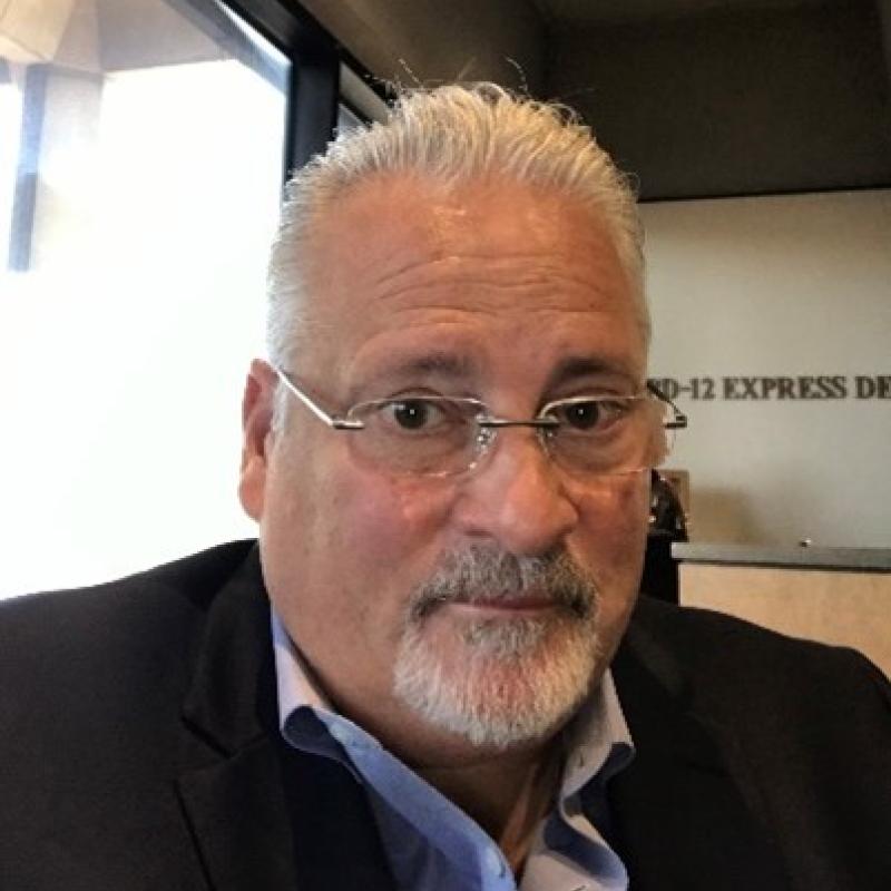 Photo of a man in a suit wearing glasses. 