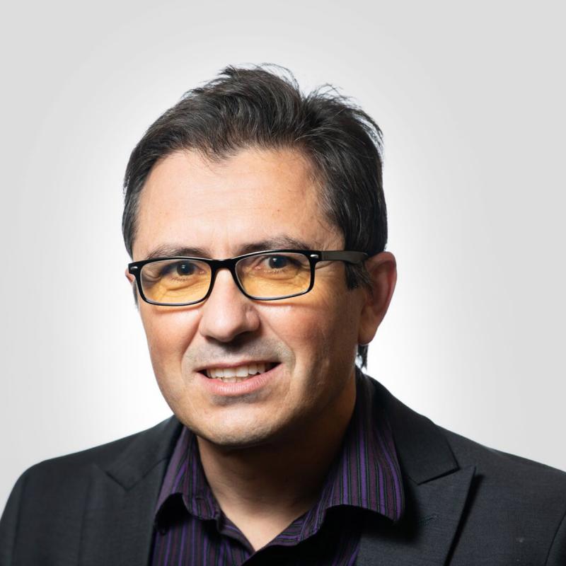 Man in glasses and dark shirt smiling