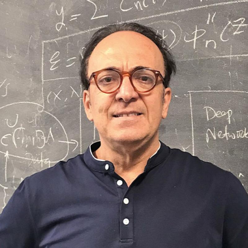 George Karniadakis standing in front of chalkboard