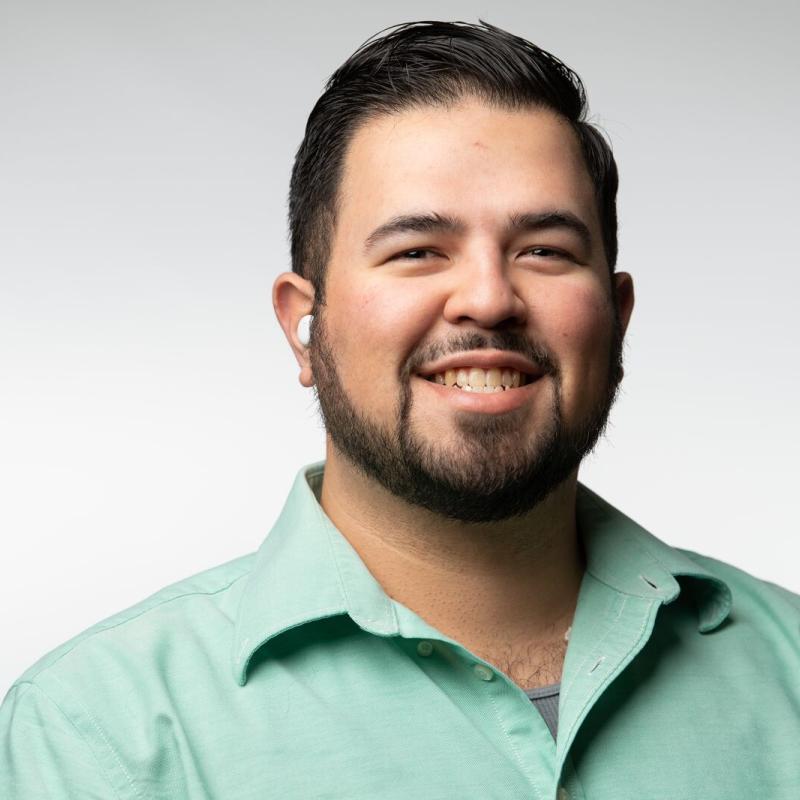 Adan Schafer Medina, with dark hair wearing a green shirt