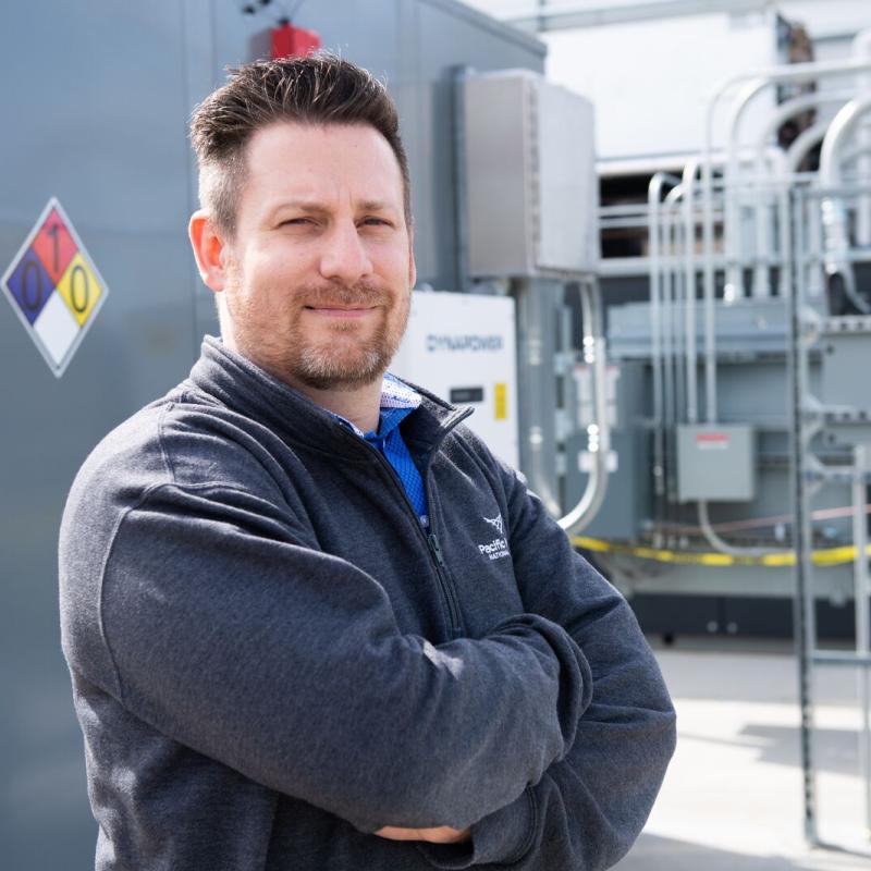 Man in grey sweatshirt with folded arms
