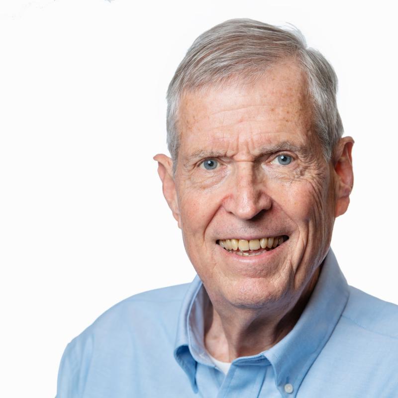 Photograph of a smiling man wearing business attire