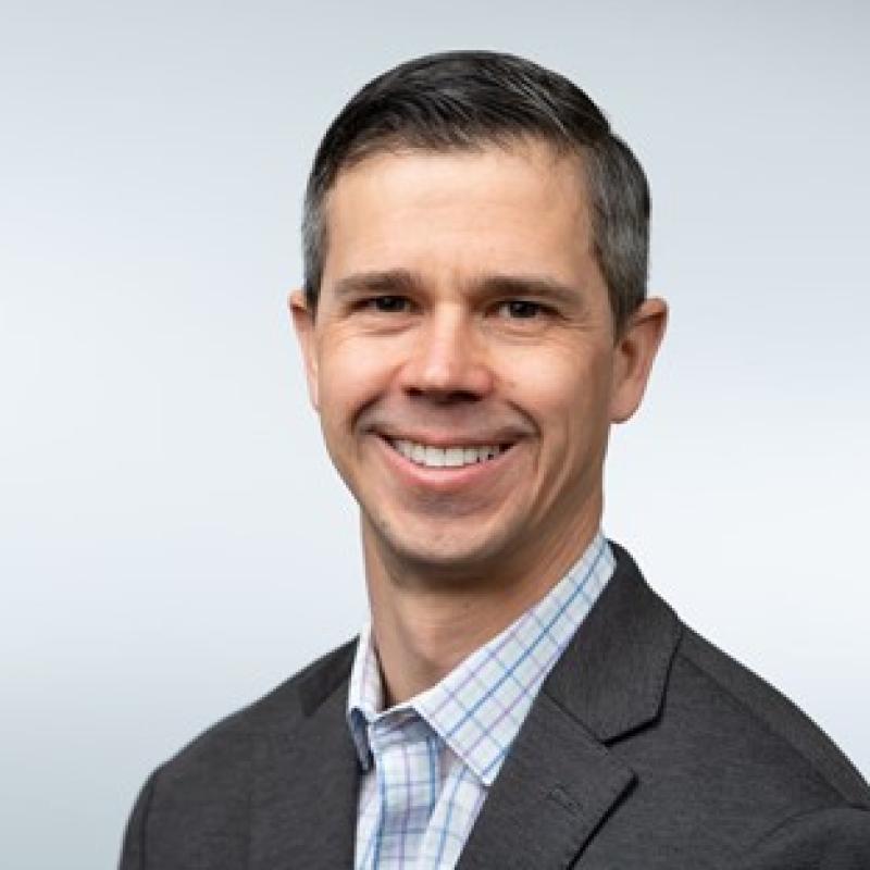 Image of a smiling man dressed in business attire