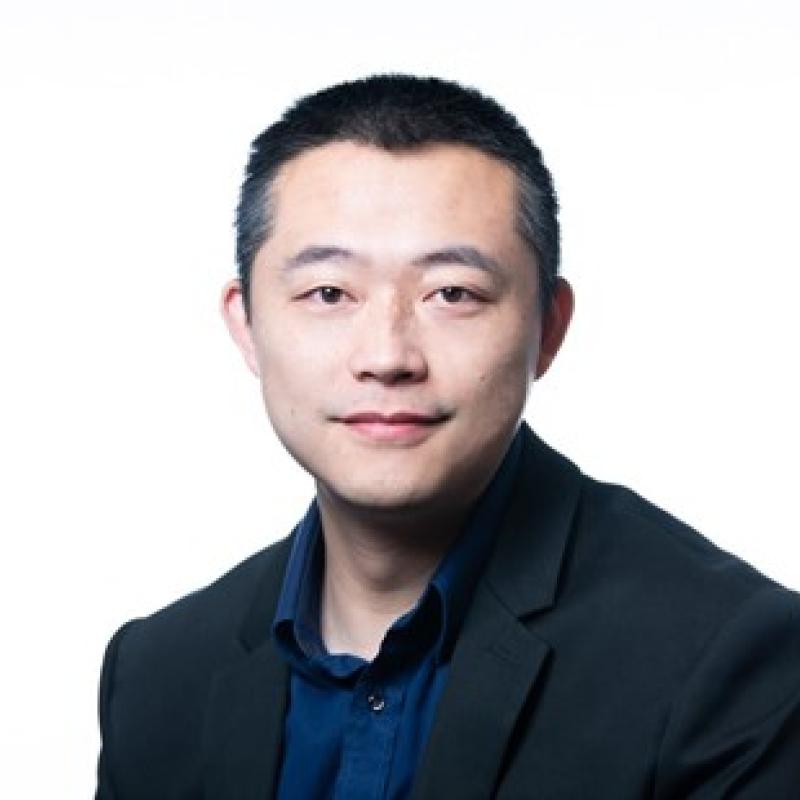 Photograph of a smiling man wearing business attire