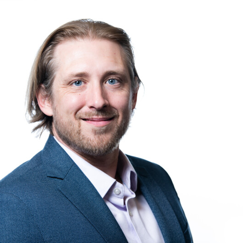 Smiling man with medium length hair wearing business atire