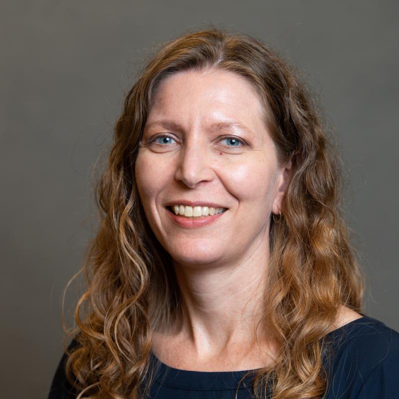 Photograph of a smiling woman with curly hair