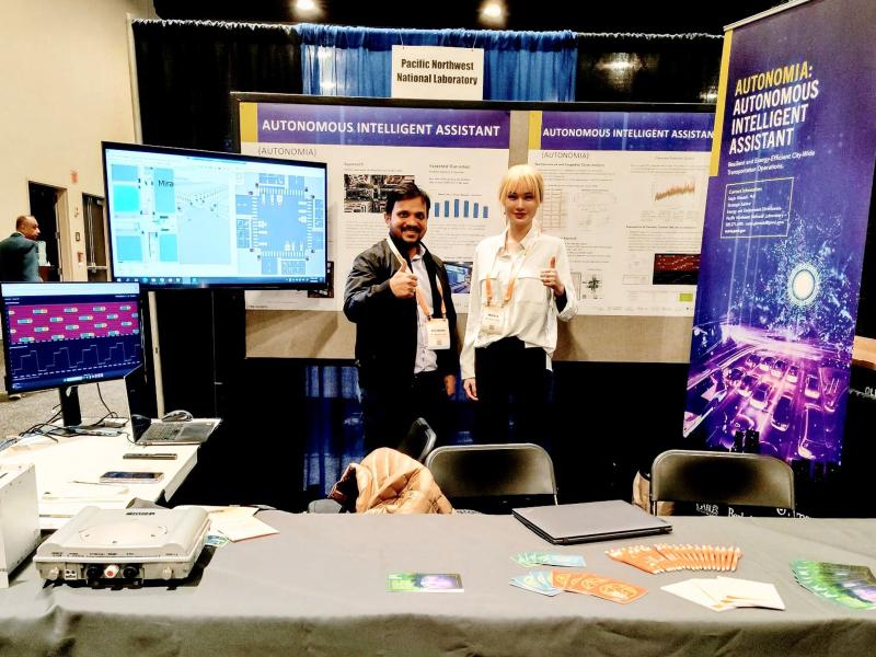 Two people standing within an exhibit booth at ARPA-E event.